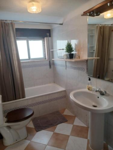 uma casa de banho com um lavatório, uma banheira e um WC. em Casa Familiar Boa Fé em Elvas