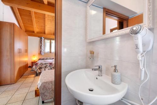 ein Badezimmer mit einem Waschbecken und einem Haartrockner an der Wand in der Unterkunft La Fonte di Mariella Monolocale 1 in Dosso del Liro
