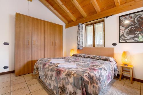 Schlafzimmer mit einem Bett und einem Holzschrank in der Unterkunft La Fonte di Mariella Monolocale 1 in Dosso del Liro