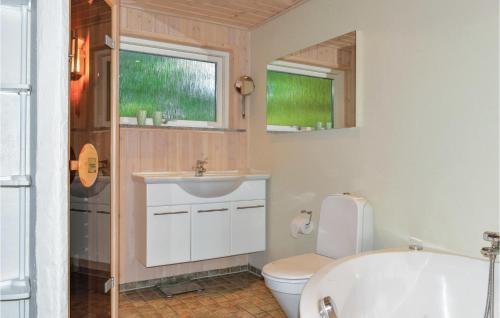 uma casa de banho com um WC, um lavatório e uma banheira em Awesome Home In lbk With Sauna em Ålbæk