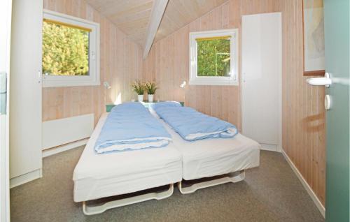 Cette chambre comprend un grand lit et 2 fenêtres. dans l'établissement Cozy Home In Blvand With Kitchen, à Blåvand