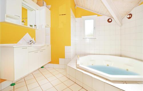 La salle de bains est pourvue d'une baignoire et d'un lavabo. dans l'établissement Cozy Home In Blvand With Kitchen, à Blåvand