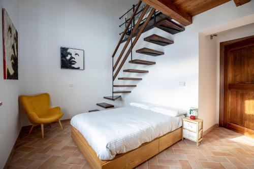 a bedroom with a bed and a spiral staircase at Villa Ermelinda - Matrimoni, piscina e jacuzzi in Castelraimondo