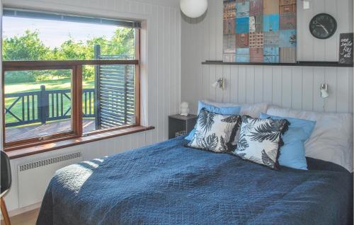 a bedroom with a bed with blue sheets and a window at Beautiful Home In Jerup With 4 Bedrooms, Sauna And Wifi in Jerup