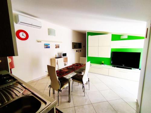 une salle à manger avec une table, des chaises et un mur vert dans l'établissement Colorful House Costa Trabocchi, à San Vito Chietino