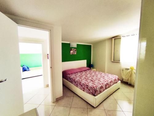 聖維托基耶蒂諾的住宿－Colorful House Costa Trabocchi，一间卧室设有一张床和绿色的墙壁