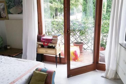 een slaapkamer met een bed en een glazen schuifdeur bij CASA degli OLIVI GARDA LAKE in Riva del Garda