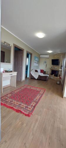 sala de estar con alfombra en el suelo de madera en Guesthouse Eirini Porto Germeno, en Aigósthena