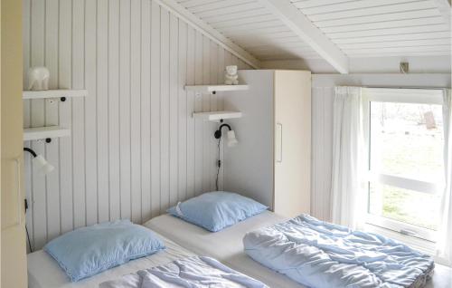 a bed with two pillows in a room with a window at 3 Bedroom Awesome Home In Strandby in Strandby