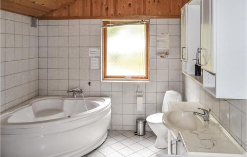 ÅlbækにあるGorgeous Home In lbk With Saunaの白いバスルーム(バスタブ、トイレ付)
