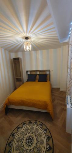 1 dormitorio con cama amarilla y techo en Appart Cosy Place Saint-Jean, en Niort