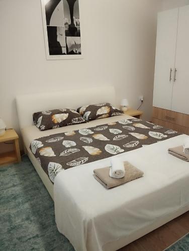 ein Schlafzimmer mit einem Bett mit einer schwarzen und weißen Decke in der Unterkunft Apartman Dream House in Mostar
