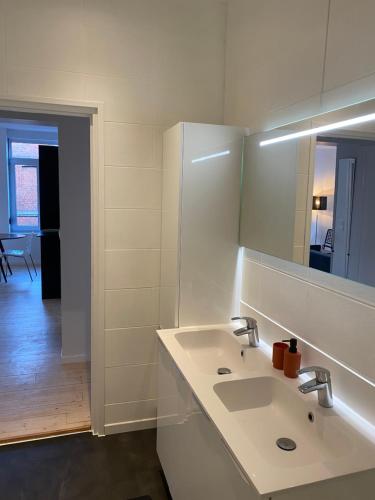 T3 lumineux en plein coeur de Moulins في ليل: حمام أبيض مع حوض ومرآة