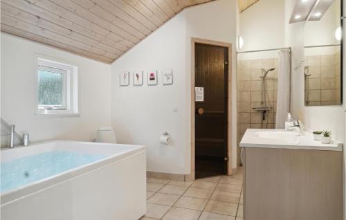 a bathroom with a large tub and a sink at Amazing Home In Ebeltoft With Wifi in Ebeltoft