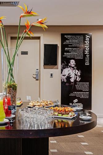 a table with a tray of food on it at Full Jazz by Slaviero Hotéis in Curitiba