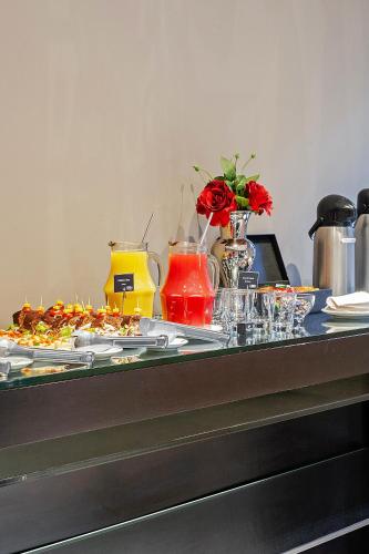 a buffet with plates of food on a table at Full Jazz by Slaviero Hotéis in Curitiba