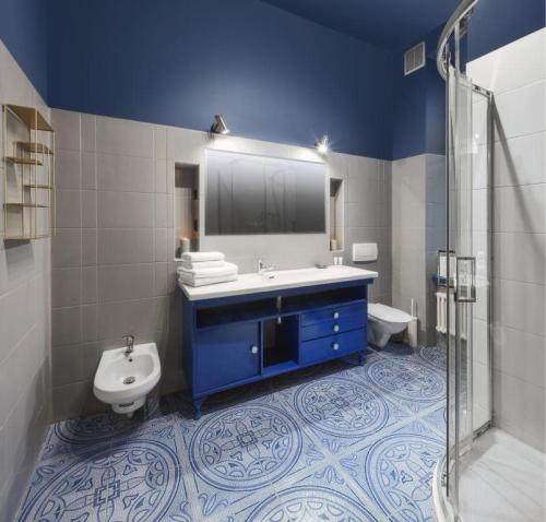 a bathroom with a sink and a toilet and a mirror at Apartamenty Piotrkowska 82 by Good Time in Łódź