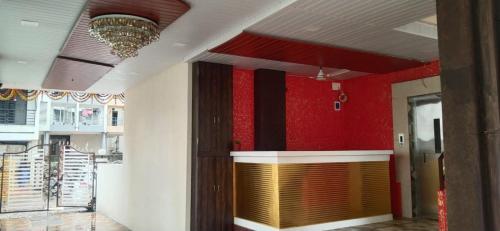um átrio com paredes vermelhas e brancas e uma porta amarela em HOTEL OM SAI em Vovale