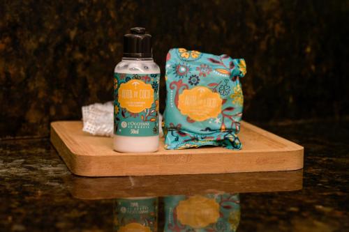 a bottle of pumpkin soap and a bag on a cutting board at Milie Lounge Pousada in Japaratinga