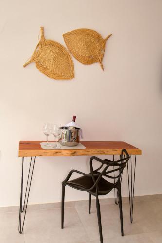 a wooden table with a chair and some leaves on the wall at Milie Lounge Pousada in Japaratinga
