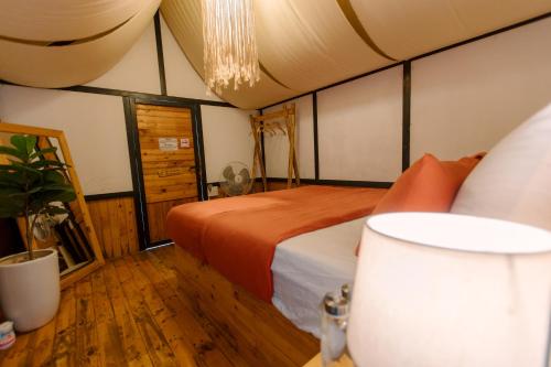 Schlafzimmer mit einem Bett und einem Kronleuchter in der Unterkunft The November - Moc Chau in Mộc Châu