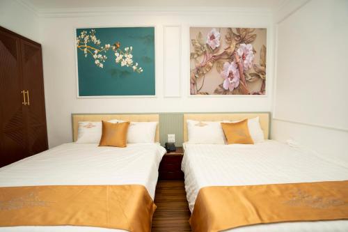 two beds sitting next to each other in a room at Hotel Trung Duong in Móng Cái