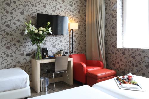 a hotel room with a red chair and a desk at Klima Hotel Milano Fiere in Milan