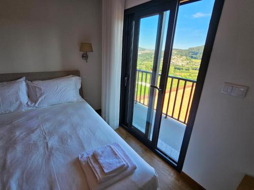 吉馬良斯的住宿－Quinta de Casal do Bairro Casa Grande，一间卧室设有一张床,享有阳台的景色