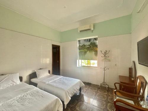 a hotel room with two beds and a window at Bach Dai Dung Hotel in Ha Tinh