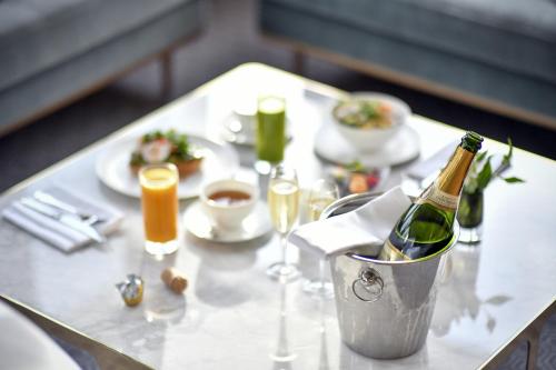 a table with a bottle of champagne and glasses on it at Royal Lancaster London in London