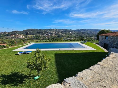 una piscina en un patio junto a una casa en Quinta de Casal do Bairro Casa Grande, en Guimarães