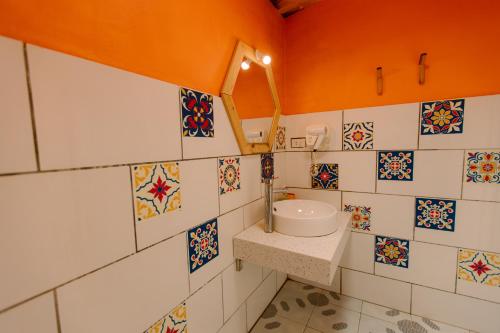 a bathroom with a sink and tiles on the wall at The November - Moc Chau in Mộc Châu
