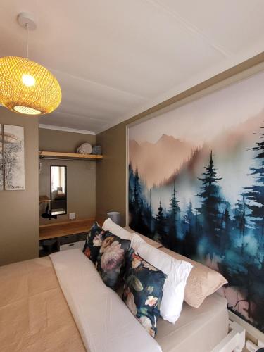 a living room with a large painting on the wall at Flamant Self-Catering Apartment in Velddrif