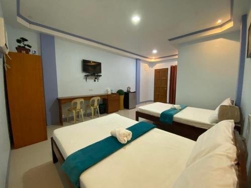 a hospital room with two beds and a tv at Merangie Travellers Inn in Dauis