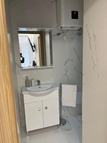 Baño blanco con lavabo y espejo en Villa Milano Apt. n. 5, en Milán