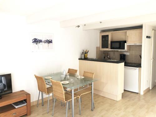 une cuisine et une salle à manger avec une table et des chaises dans l'établissement GARENNE - Duplex balcon, Plage 500m - T23, à Carnac