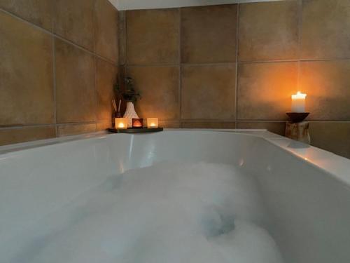 a large bath tub with two candles in a room at FEWO_ORTSZEIT in Haintchen