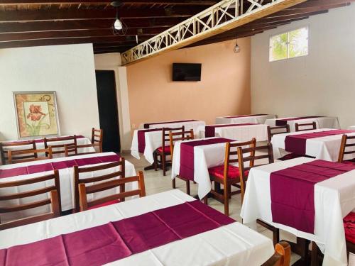 a group of tables and chairs in a restaurant at Pousada Riviera in Caraguatatuba