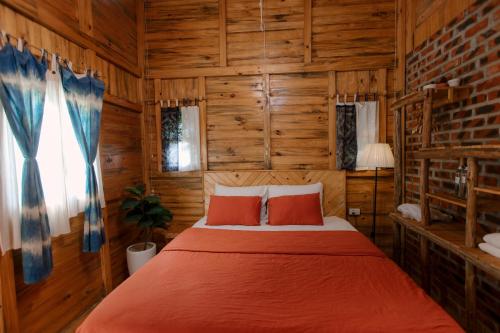 a bedroom with a bed in a room with wooden walls at The November - Moc Chau in Mộc Châu