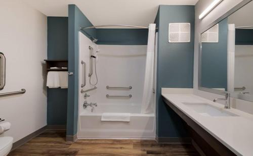 a bathroom with a tub and a sink and a shower at WoodSpring Suites Ashland - Richmond North in Ashland