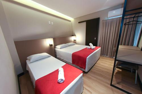 una camera d'albergo con due letti e una sedia di Arco do Sol Park Hotel a Camboriú