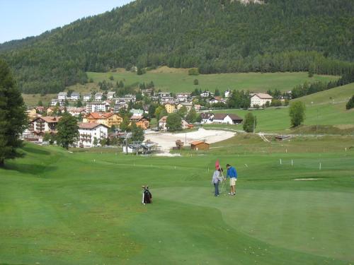 a group of people standing on a golf course at Suite a Folgaria in Folgaria
