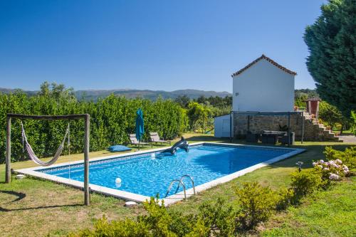 a swimming pool with a swing and a pool at Solar Alegria in Ribeiradio