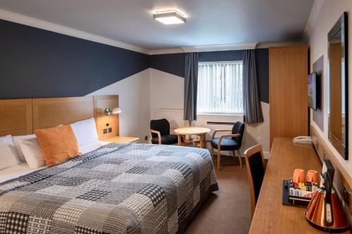 a hotel room with a bed and a table and chairs at Weetwood Hall Estate in Leeds