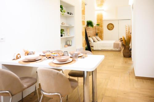 Un comedor con una mesa y sillas blancas. en Victory Suite 31, en Brindisi