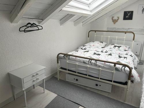 - une chambre blanche avec un lit et une table de nuit dans l'établissement Les coeurs brisés, à Crans-Montana