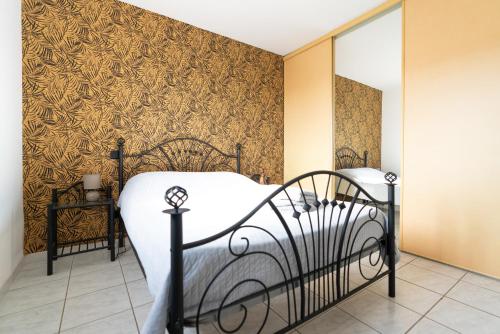 - une chambre avec un lit et du papier peint doré dans l'établissement Villa Tika, à Béziers