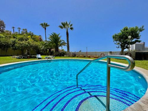 een groot blauw zwembad met palmbomen bij Costa Canaria in Santiago del Teide