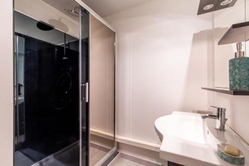 une salle de bain avec une douche en verre et un lavabo dans l'établissement Au Coeur De L'Olivette - Climatisée avec piscine, à Aubais