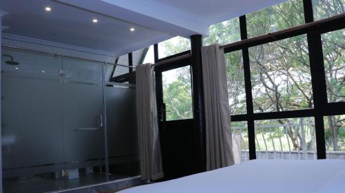 a bedroom with a shower and a glass door with a window at Brooks Lodge in Nakuru